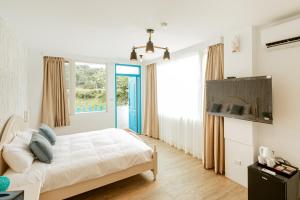 ein Schlafzimmer mit einem Bett und einem großen Fenster in der Unterkunft You Yue B&B in Hualien