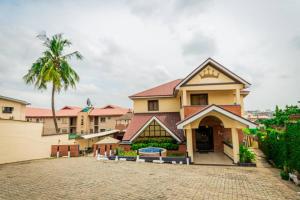 uma casa com uma palmeira em frente a uma entrada em Choice Suites III em Ikeja