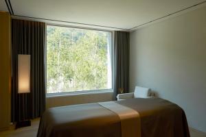 a room with a bed and a large window at PARK ROCHE Resort & Wellness in Jeongseon