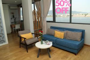 uma sala de estar com um sofá azul e uma mesa em KaKa Hotel Han River em Da Nang