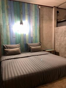 a large bed in a room with a green wall at Samanta By The Sea in Ko Larn