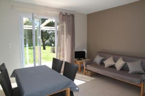 ein Wohnzimmer mit einem Sofa und einem Tisch in der Unterkunft Domaine Les 4 Vents in Patrimonio