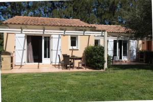 a house with a patio with a table in a yard at Domaine Les 4 Vents in Patrimonio