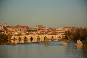un puente sobre un río con una ciudad en el fondo en Hostal Don Rodrigo, en Zamora