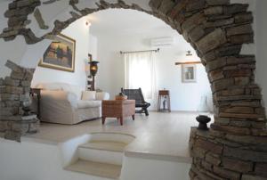 a living room with a stone archway in a living room at Medusa Beach Resort & Suites in Plaka