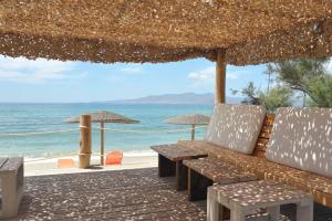 a table and chairs on a beach with the ocean at Medusa Beach Resort & Suites in Plaka