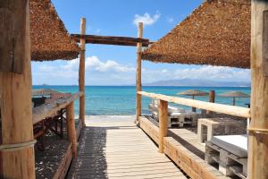 a wooden pathway to the beach with the ocean at Medusa Beach Resort & Suites in Plaka