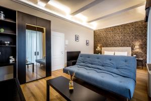 a living room with a blue couch and a table at Martelli 6 Suite & Apartments in Florence
