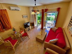 a living room with a red couch and a table at La Riviera Barbati Seaside Apartments & villas in Barbati
