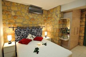 um quarto com uma grande cama branca com almofadas vermelhas em Messinian Horizons em Marathópolis