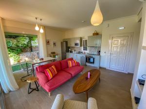 a living room with a red couch and a table at La Riviera Barbati Seaside Apartments & villas in Barbati