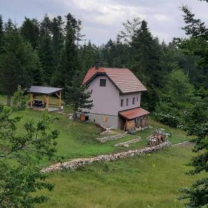 a white house with a gazebo in a field at My Home Tara in Mitrovac