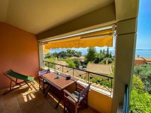 a balcony with a table and chairs and a window at La Riviera Barbati Seaside Apartments & villas in Barbati