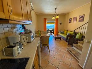 a kitchen with a counter and a living room at La Riviera Barbati Seaside Apartments & villas in Barbati
