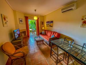 a living room with a couch and a glass table at La Riviera Barbati Seaside Apartments & villas in Barbati