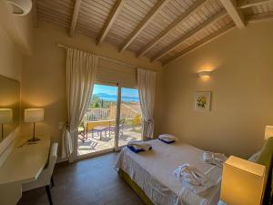 a bedroom with a bed and a desk and a window at La Riviera Barbati Seaside Apartments & villas in Barbati
