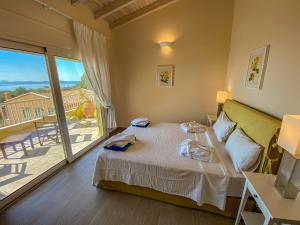 a bedroom with a bed and a balcony at La Riviera Barbati Seaside Apartments & villas in Barbati