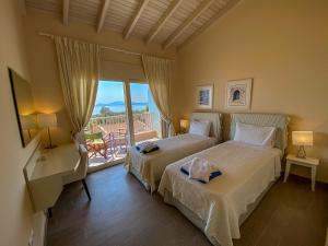 a bedroom with two beds and a balcony at La Riviera Barbati Seaside Apartments & villas in Barbati