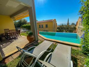 a patio with two chairs and a swimming pool at La Riviera Barbati Seaside Apartments & villas in Barbati