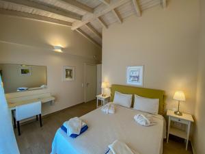 a bedroom with a large bed and a desk at La Riviera Barbati Seaside Apartments & villas in Barbati