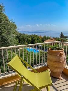a green chair and a vase on a balcony at La Riviera Barbati Seaside Apartments & villas in Barbati