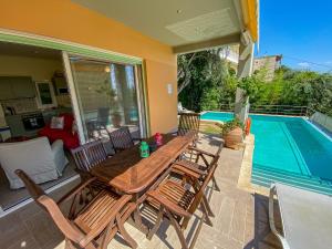 a patio with a table and chairs next to a swimming pool at La Riviera Barbati Seaside Apartments & villas in Barbati