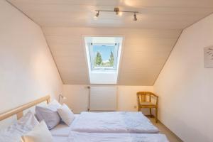 ein kleines Schlafzimmer mit einem Bett und einem Fenster in der Unterkunft Ferienwohnung zum Seeblick in Öhningen
