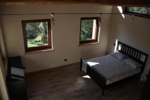 um quarto com uma cama e duas janelas em Residenza di Campagna em Chiaverano