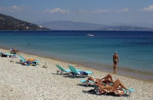 a group of people laying in lawn chairs on a beach at La Riviera Barbati Seaside Apartments & villas in Barbati
