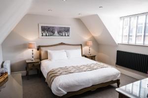 ein Schlafzimmer mit einem großen weißen Bett und zwei Lampen in der Unterkunft The Boot at Melbourne in Derby