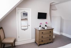 a bedroom with a white door and a dresser with a mirror at Harpur's of Melbourne in Melbourne