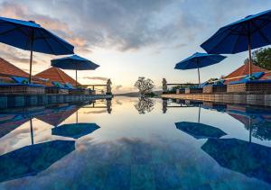 a pool of water with umbrellas on top of it at Island Retreat Cottage in Nusa Lembongan