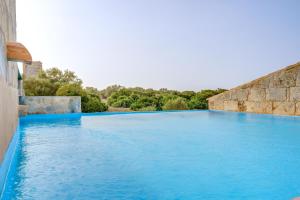 a large swimming pool with blue water at Possessio Sa Barrala Casa del Pages in Campos