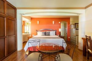 a bedroom with a bed and a glass table at Hotel Ángel Inn in Oaxaca City