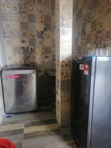 a kitchen with a refrigerator and a trash can at Rimba Panjang 152-4 Pax in Kampong Rimba Panjang