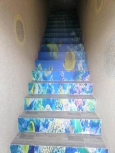 a set of stairs with a painting of oceans and planets at Rimba Panjang 152-4 Pax in Kampong Rimba Panjang