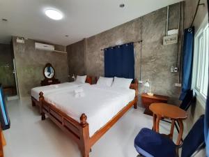 um quarto com uma cama, uma mesa e cadeiras em Pottery Street House em Sukhothai