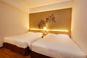 duas camas num quarto com lençóis brancos em Hotel Six Seasons @ Mid Valley em Kuala Lumpur