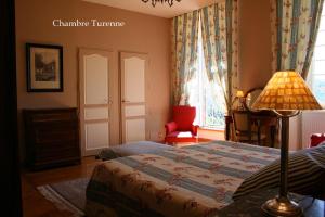 1 dormitorio con cama, lámpara y silla en Château de La Grèze, en Beaulieu-sur-Dordogne