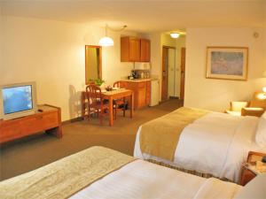 a hotel room with two beds and a television at Rosemont Suites in Norwich