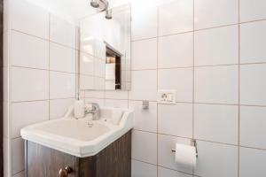 La salle de bains blanche est pourvue d'un lavabo et d'un miroir. dans l'établissement La Buhardilla de La Vicaría, à La Laguna