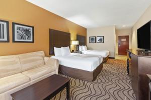 a hotel room with two beds and a couch at La Quinta by Wyndham South Bend in South Bend
