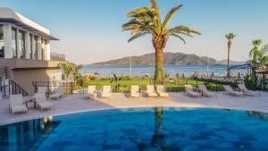 a pool with chairs and a view of the water at Premier Nergis Beach & SPA in Marmaris