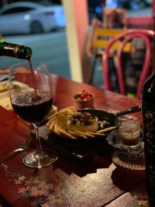 ein Glas Wein und ein Teller mit Essen auf dem Tisch in der Unterkunft Magenta in Donghae