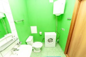 エカテリンブルクにあるAbazhur Apartment Ekaterinburg Stachekの緑豊かなバスルーム(トイレ、洗濯機付)