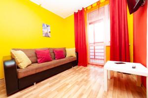 een woonkamer met een bank in een gele kamer bij Abazhur Apartment Ekaterinburg Stachek in Jekaterinaburg