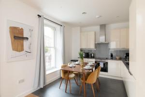 una cucina con tavolo e sedie in una stanza di London City Apartments - Luxury and spacious apartment with balcony a Londra