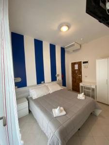 a bedroom with a large bed with blue and white stripes at Hotel Las Vegas in Riccione