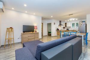 salon z niebieską kanapą i kuchnią w obiekcie Holiday house TRANQUILLITY w mieście Gabonjin