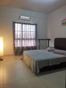 ein Schlafzimmer mit einem Bett und einem Fenster mit einem Vorhang in der Unterkunft Marina@terryHOMES in Port Dickson